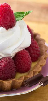Colorful raspberry tart with whipped cream on a wooden table.