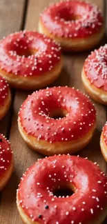 Red iced donuts on a wooden background.