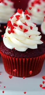 Red velvet cupcakes with frosting and heart sprinkles.