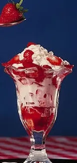 Strawberry sundae with whipped cream atop a glass serving dish.