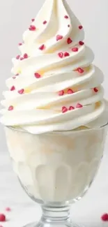 Vanilla swirl ice cream with red candy hearts in a glass.