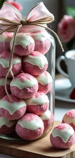 Jar of pink cookies with white topping, elegantly displayed.