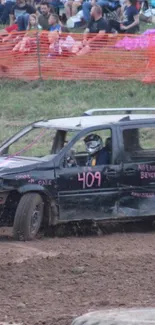 Demolition derby car racing on a muddy track.