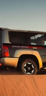 SUV driving through desert sand dunes with sunset backdrop.