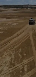 Off-road vehicle on desert path with rugged terrain.