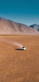 Car driving through vast desert landscape with mountains.