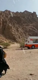 Desert landscape featuring a campervan and a solitary traveler