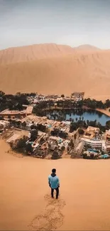 Traveler overlooking desert oasis landscape with sand dunes