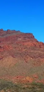 Red desert mountain under clear blue sky wallpaper.