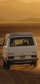 Van driving in golden desert landscape at sunset.