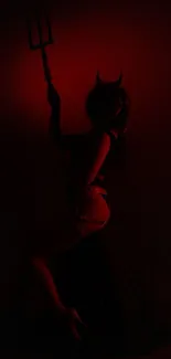 Dark silhouette with devil horns in red light.