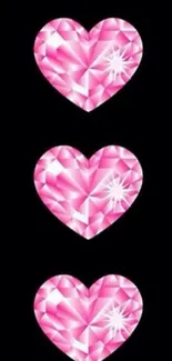 Three pink diamond hearts on black background.