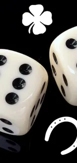 Ivory dice with clover and horseshoe on black background.