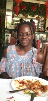 Woman in floral dress dining in a vibrant restaurant.