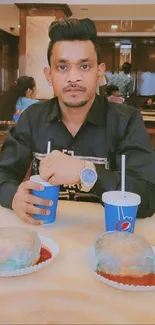 A man dining in an elegant cafe setting with food and drinks.