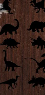 Dinosaur silhouettes on brown wood background wallpaper.