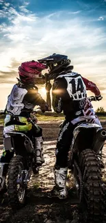 Two motocross riders at sunset on dirt bikes.