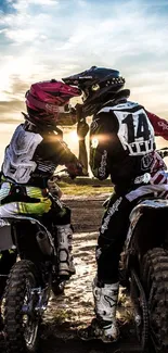 Motocross riders at sunset on dirt bikes.