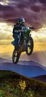 Dirt bike jumps against a vibrant sunset over mountains.