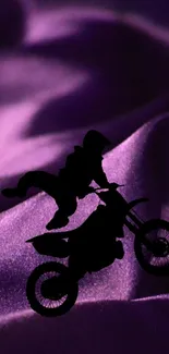 Silhouette of a rider on a dirt bike with a purple wave background.