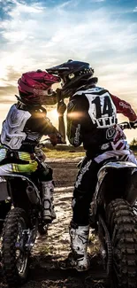 Motocross couple kissing at sunset with dirt bikes.