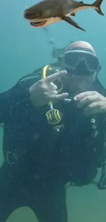 Scuba diver with yellow gear and shark underwater.