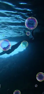 Silhouette of a diver surrounded by bubbles in a dark underwater scene.