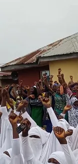 Diverse group celebrating with raised hands in unity and joy.