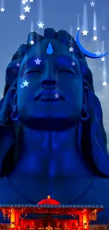 Divine blue Shiva statue under a starry night sky.