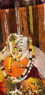 Orange idol beautifully adorned with flowers and colorful decorations.