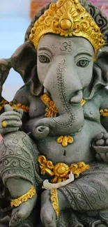 Gray stone Ganesha statue with intricate gold details.