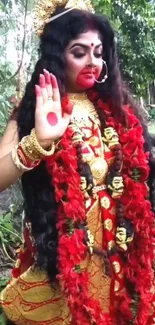 Divine goddess in red attire standing in a natural setting with greenery.