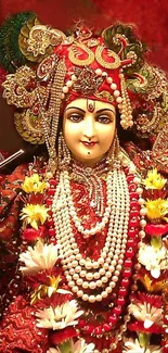 Goddess adorned in red with floral and gold decorations.