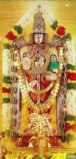 Vibrant Hindu deity in a temple setting, adorned with gold and floral decorations.