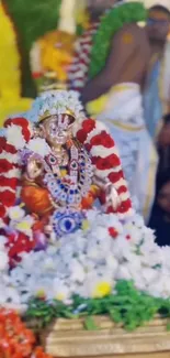 Divine idol adorned with vibrant flowers.