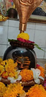 Shiva Lingam with marigold flowers and cobra sculpture.