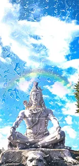 Shiva statue with a rainbow in the background against a sky blue backdrop.