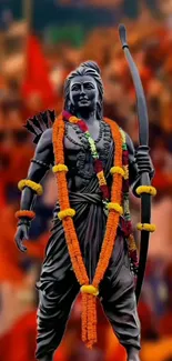 Statue of a divine warrior with garlands against a vibrant red-orange background.