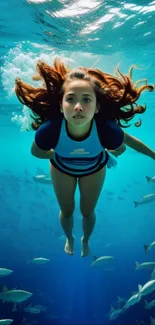 Girl diving underwater surrounded by fish in vibrant blue ocean.