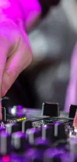 Close-up of DJ's hands on a vibrant mixing console