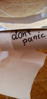 Don't Panic message on empty toilet paper roll.