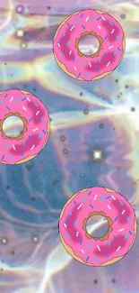 Three pink-sprinkled donuts float in a vibrant galaxy background.