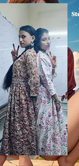 Two women in floral dresses posing for a portrait.