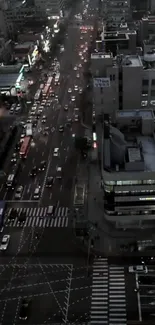 Aerial view of a bustling city street at night, with traffic and illuminated buildings.