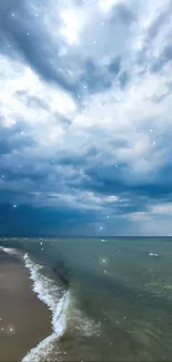 Dramatic cloudy sky above serene beach and ocean waves.