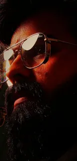 Close-up portrait of bearded man with sunglasses in dramatic lighting.