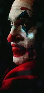 Dramatic red-cloaked clown portrait against a dark background.