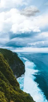 Dramatic view of a coastal cliff over a blue ocean with a cloudy sky.