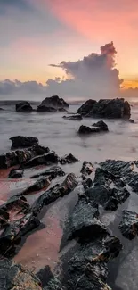 Coastal sunset scene with rocks and colorful sky.