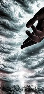 Hand reaching into a dramatic stormy sky wallpaper.